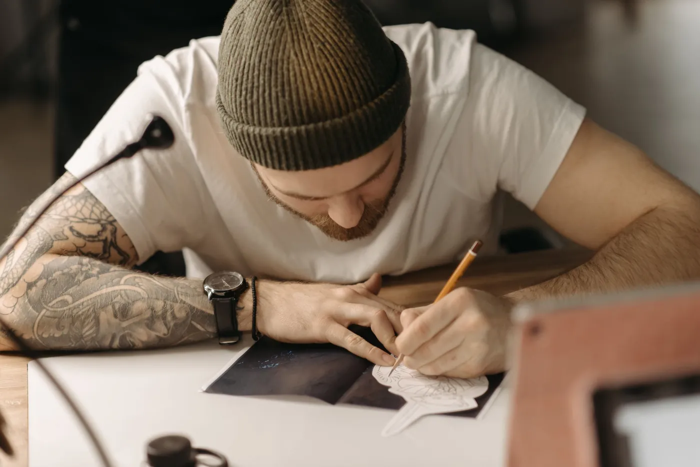 Artist care desenează de mână schița unui tatuaj