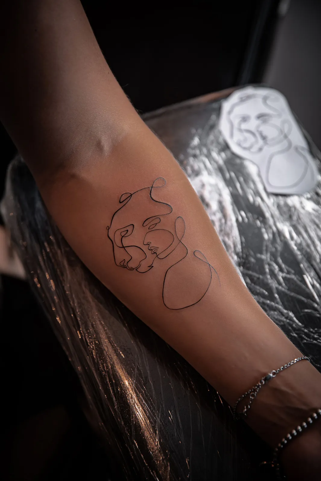 Portret în linie continuă, tatuat fine line pe antebraț